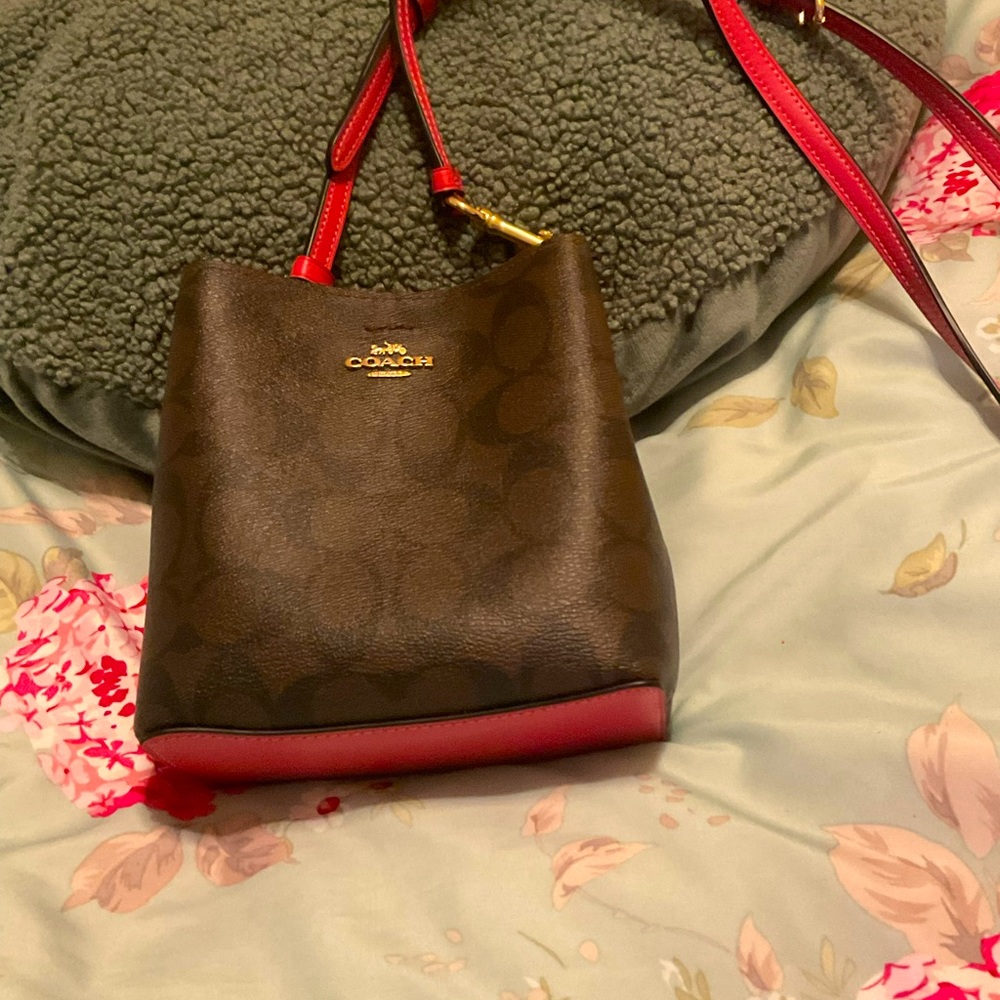 Crossgrain leather Inside open pocket zip top closure Detachable strap